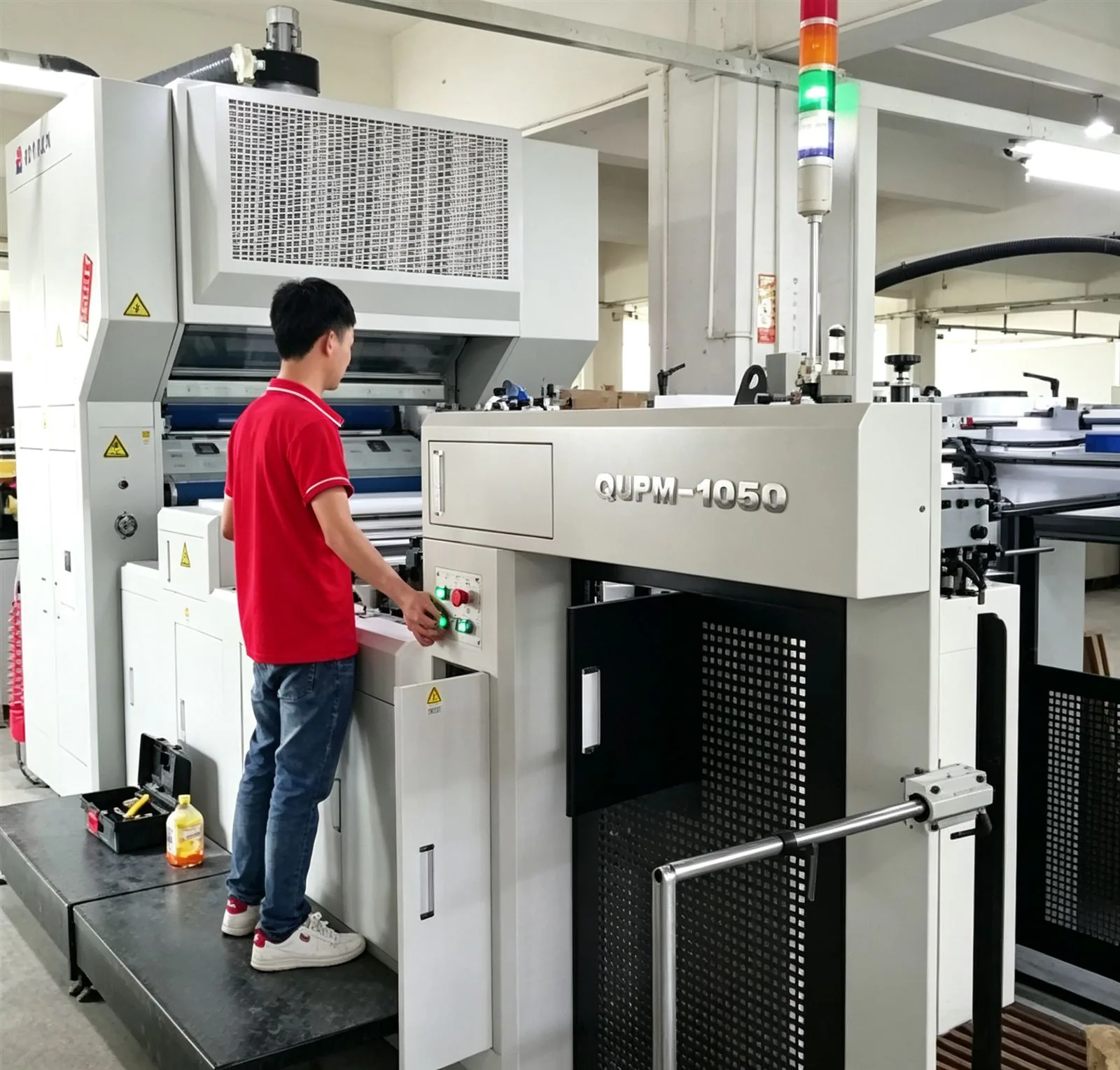 A die-cut operator running a corrugated blank on the factory line, cutting clean parts for custom cat scratchers.