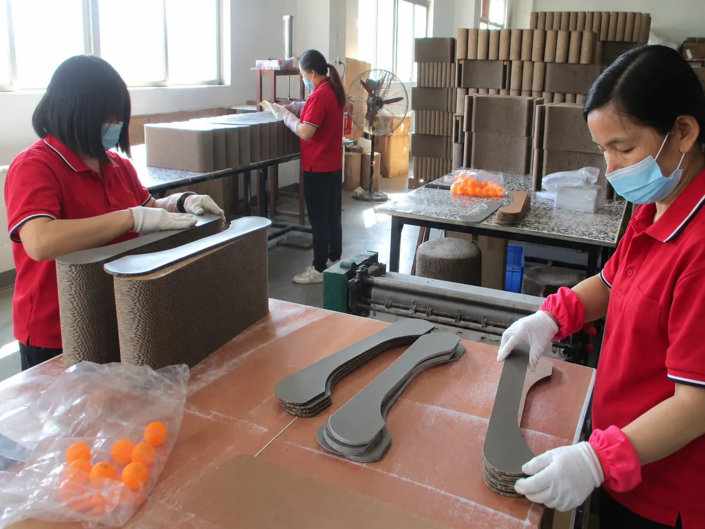 The assembly team building corrugated scratcher lounges by hand, checking each curve before it leaves the bench.