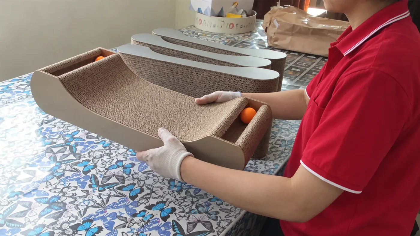 A corrugated scratcher lounge with a play ball, shaped for both a scratch and a short game.