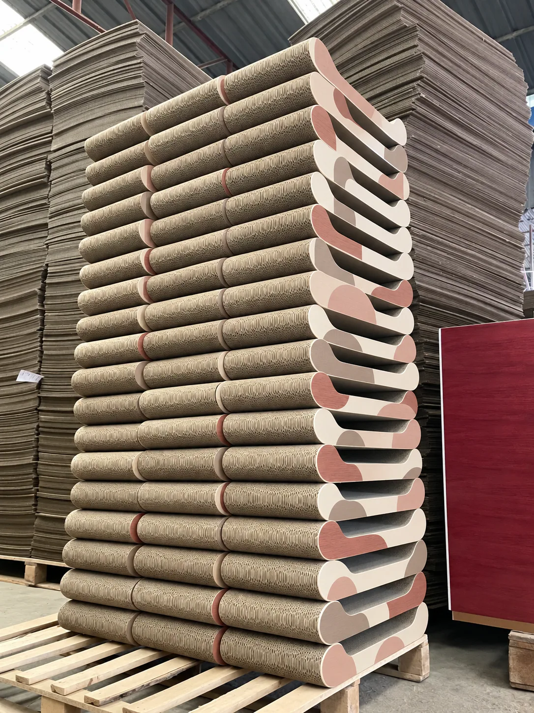 Pastel lounge scratchers in a tall retail stack, soft color on a sturdy corrugated curve.