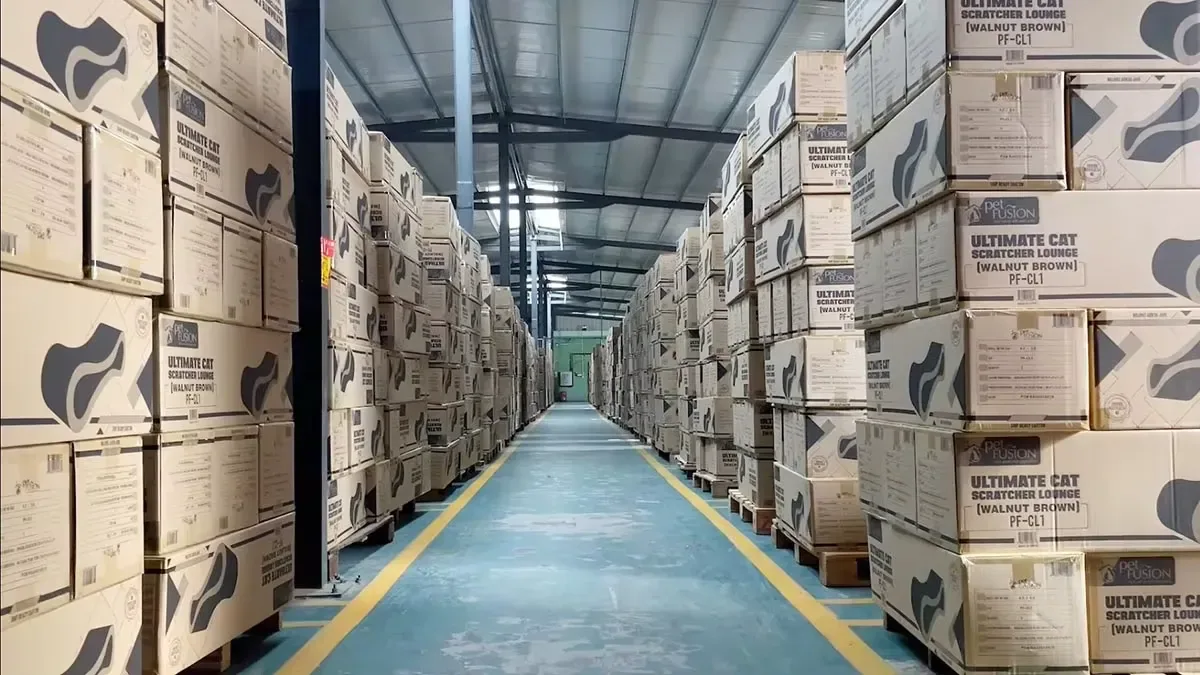 Finished cat scratcher cartons lining a warehouse export aisle.